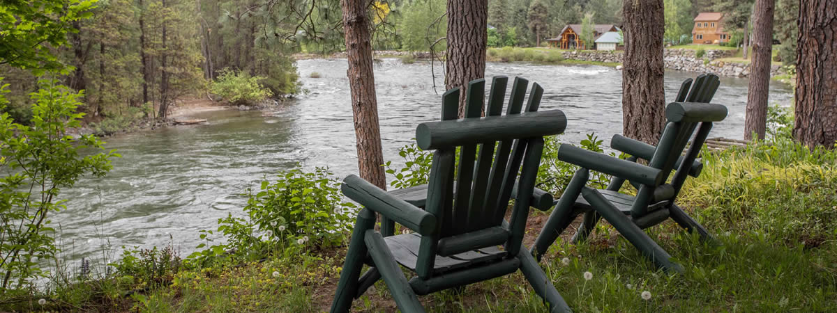 pair of chairs overlooking the river and forest